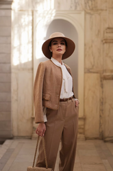 a lady wears a brown jacket with brown pants and white blouse